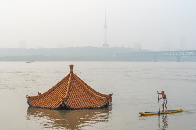 Oversvømmelser i Kina etterlater dusinvis av døde mens ekstrem varme rammer landet